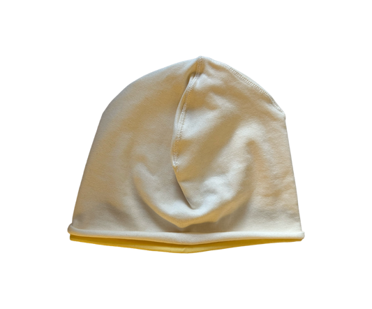 A soft knit beanie hat in a warm off-white or cream color, shown against a plain white background.